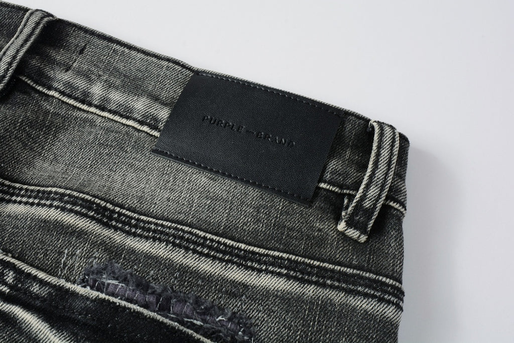 Jeans de mezclilla en tono gris lavado oscuro, acabado desgastado estilo vintage.