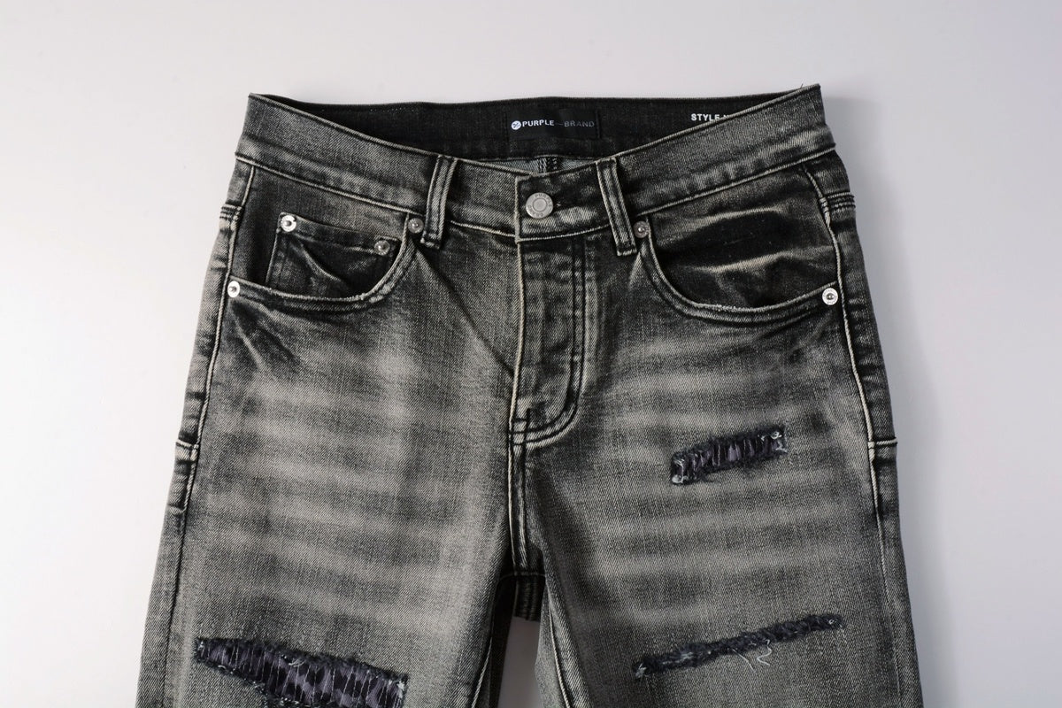Jeans de mezclilla en tono gris lavado oscuro, acabado desgastado estilo vintage.