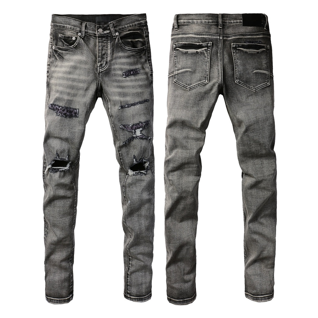 Jeans de mezclilla en tono gris lavado oscuro, acabado desgastado estilo vintage.