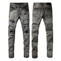 Jeans de mezclilla en tono gris lavado oscuro, acabado desgastado estilo vintage.