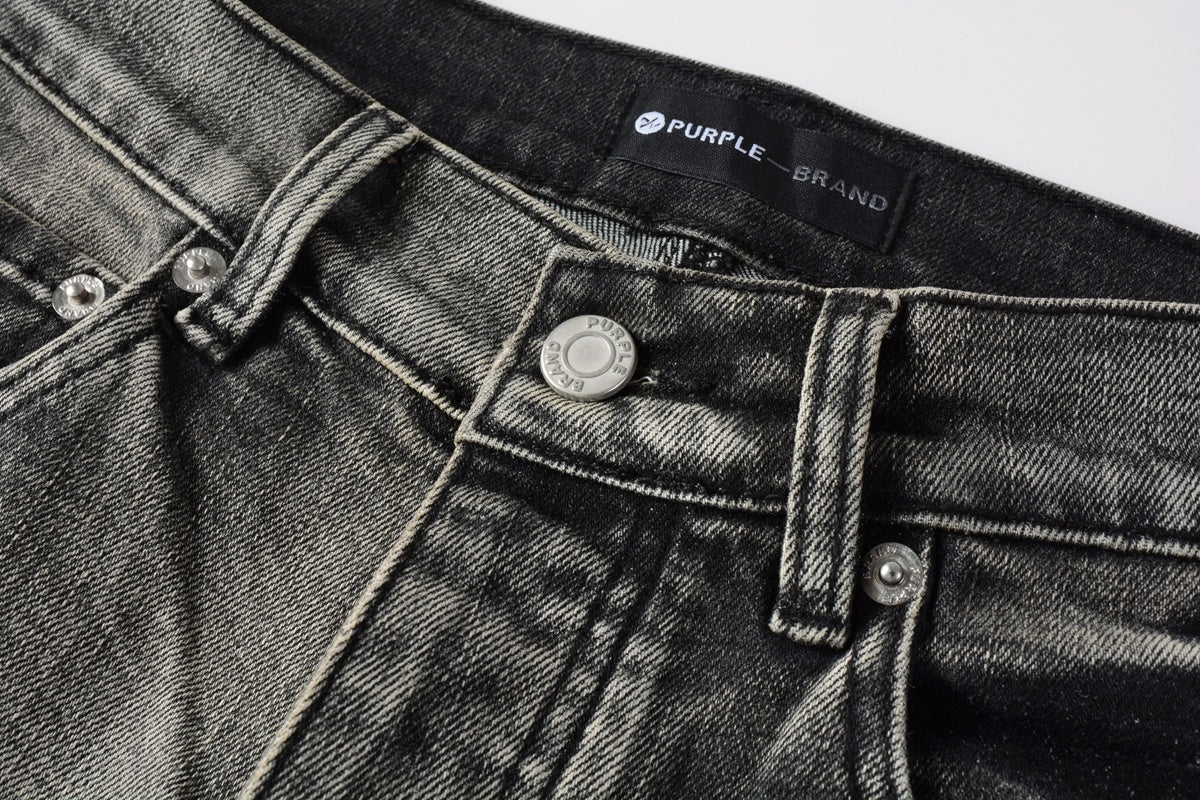 Jeans de mezclilla en tono gris lavado oscuro, acabado desgastado estilo vintage.